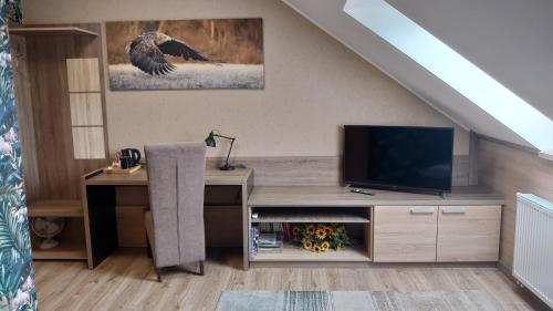 a living room with a tv and a desk at FitnessFun in Krzyż