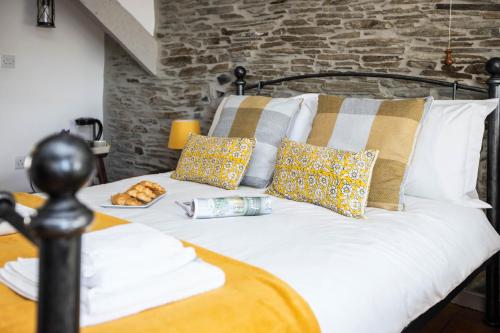 a white bed with pillows on top of it at The Olde Malthouse Inn in Tintagel