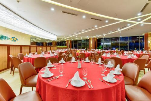 a banquet hall with red tables and chairs at Regalia Gold Hotel in Nha Trang