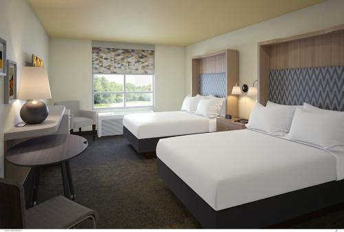 a hotel room with two beds and a desk at Holiday Inn Lexington - Hamburg by IHG in Lexington