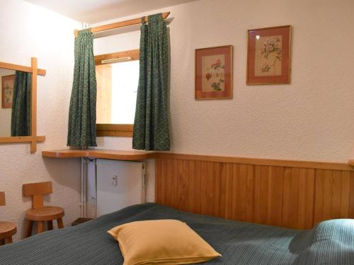 a bedroom with a bed and a window with green curtains at Appartement 3 pièces avec balcon et WIFI à 150m des pistes, 6 personnes - Méribel - FR-1-180-155 in Méribel