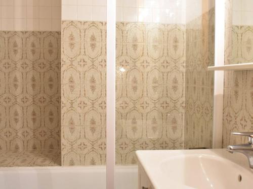 - deux vues sur une salle de bains pourvue d'une baignoire et d'un lavabo dans l'établissement Charmant appartement 2 pièces 6 personnes, proche pistes et commerces - FR-1-180-349, à Méribel