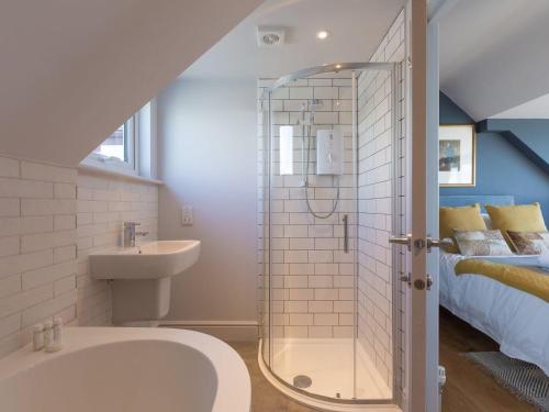 a bathroom with a shower and a sink and a bed at Marchbourne in St Ives