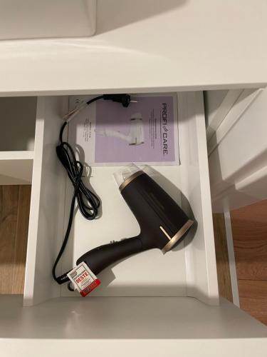 a hairdryer in a drawer of a desk at PINEA Apartments Pobierowo z niesamowitym widokiem na morze oraz jacuzzi w wybranych apartamentach in Pobierowo