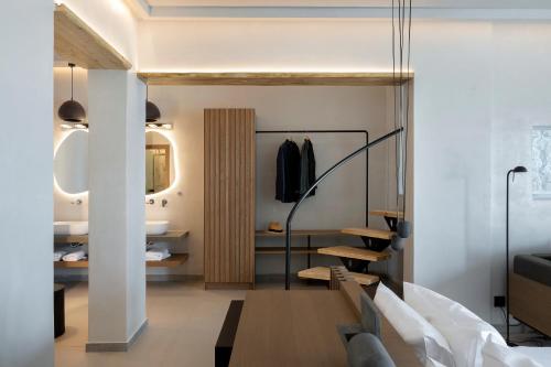 a room with a bed and a table and a mirror at Hom Santorini in Oia