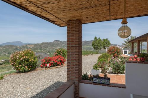 vistas a un jardín con flores en un patio en Finca Feliz Andaluz, en Álora