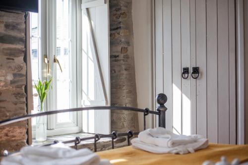 a room with a bed and a window with towels at The Olde Malthouse Inn in Tintagel