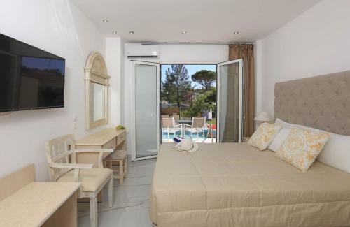 a living room with a bed and a table and a kitchen at Cavomarina Beach- Adults Only in Kavos