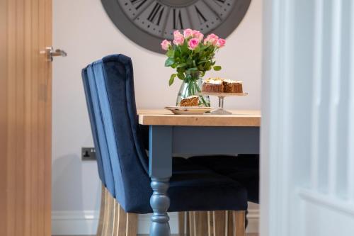a table with a vase of pink flowers and a cake at The Old Doghouse in York