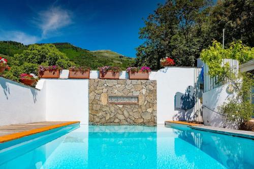 una piscina con acqua blu e pareti bianche di Villa Salvatorosa a Vico Equense