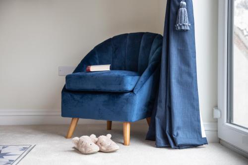 a blue chair sitting next to a window next to shoes at The Old Doghouse in York