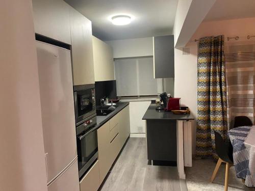 une cuisine avec des armoires blanches et un comptoir noir dans l'établissement bien-être, à Cannes