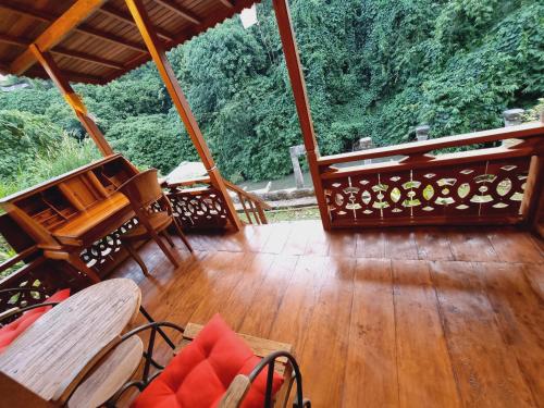 a porch with wooden floors and chairs on a deck at Avalon Ubud Castle & SPA in Ubud