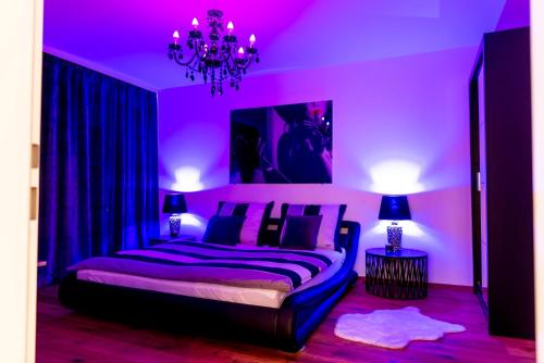 a purple bedroom with a bed and a chandelier at Wien-Appartement, Contactless - Self-Check-In in Vienna