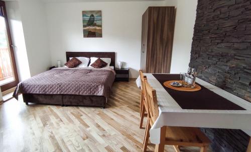 1 dormitorio con cama, mesa y comedor en Noclegi Kalniczka en Tarnawa Dolna