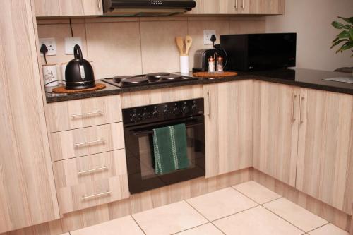 a kitchen with a stove and a microwave at 43 Home self Catering with backup power in eMalahleni