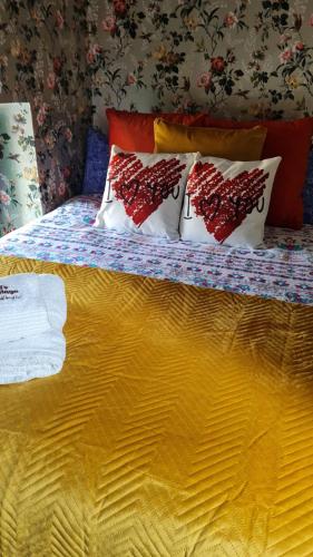 a bed with four pillows on top of it at Charming 2-Bed House in West Cork Cupid's Cottage in Kealkill
