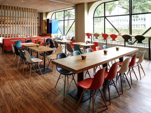 eine Cafeteria mit Tischen, Stühlen und Fenstern in der Unterkunft ibis Strasbourg Centre Historique in Straßburg