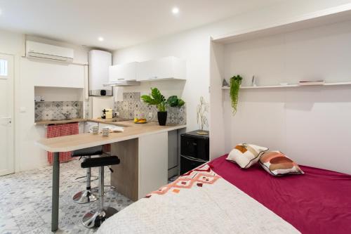 Cet appartement comprend une chambre avec un lit et une cuisine avec des placards blancs. dans l'établissement Cannes Hyper Centre climatisé, à Cannes