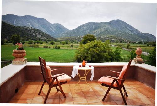 d'un balcon avec une table, des chaises et des montagnes. dans l'établissement villa archontiko ASKYFOU SFAKIA, à Karés