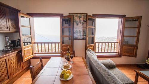 a dining room with a table and chairs and windows at HolidaynorthTenerife Caserío Rural Los Charcos in Icod de los Vinos