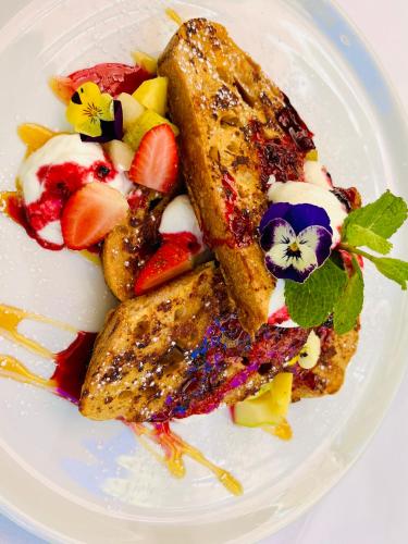 a white plate of food with fruit on it at Old Foundry Hotel by Ideas Cartel in Cape Town