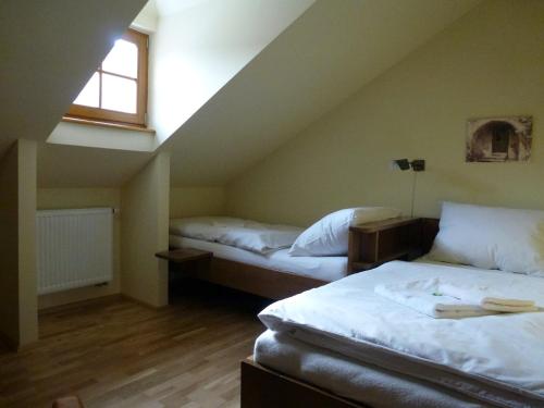 a attic room with two beds and a window at Ubytovanie u Janusa in Levoča