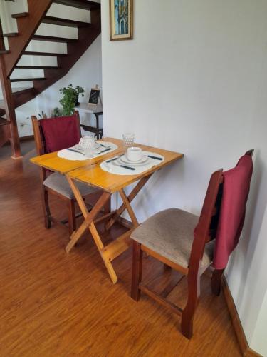 a dining room table and chairs with a wooden table at SILVÉRIOS Suítes DA MONTANHA in Campos do Jordão