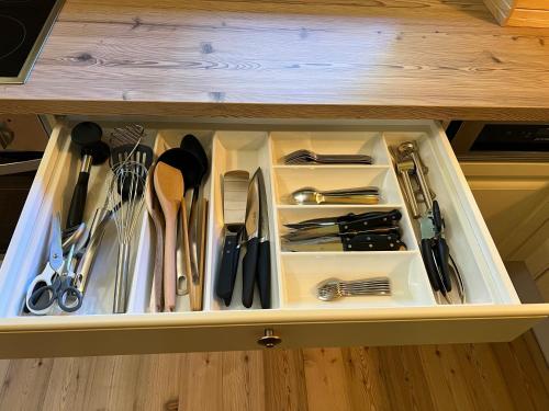 a drawer filled with utensils in a cabinet at Waldchalet am Eichhof in Innsbruck