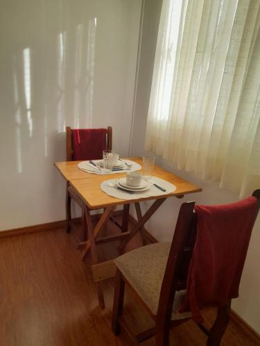uma mesa de jantar e cadeiras com uma mesa de madeira e uma mesa e cadeira em SILVÉRIOS Suítes DA MONTANHA em Campos do Jordão