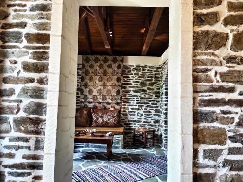 a living room with a stone wall and a couch at KERAMIDI GUESTHOUSE in Keramídhion