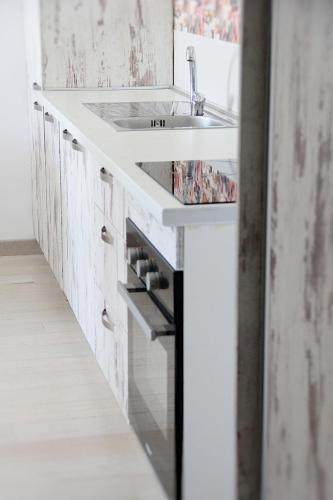 a white bathroom with a sink and a mirror at Apartment Sunset in Kotor