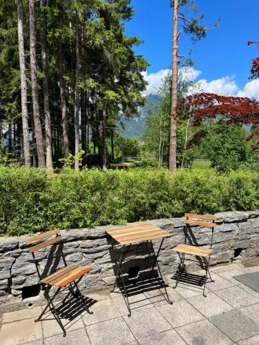 a wooden table and chairs and a stone wall at Waldchalet am Eichhof in Innsbruck