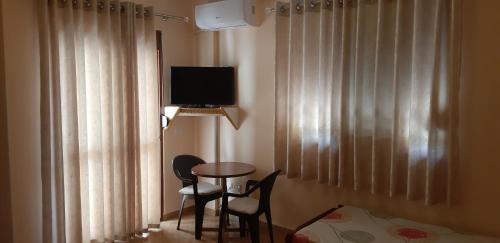 a room with a table and two chairs and a television at Amras house in Durrës
