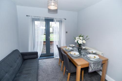 a dining room with a table and a couch at Newfield House in Crewe