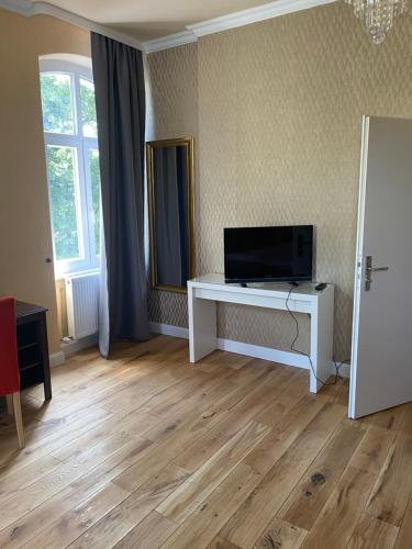 a living room with a television and a white table at Pension Zur Fähre in Boppard