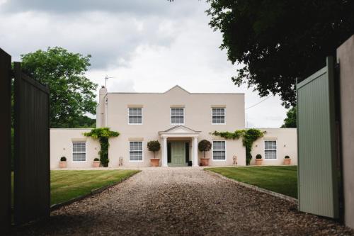 a white house with a green door and a gravel driveway at Large Country House - Hot Tub - Pool Table - BBQ - 5 Bedrooms - Log Burner in Three Legged Cross