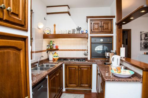 a kitchen with wooden cabinets and a sink at Gaia Albenga in Albenga