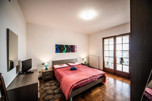 a bedroom with a bed and a television and a window at Gaia Albenga in Albenga