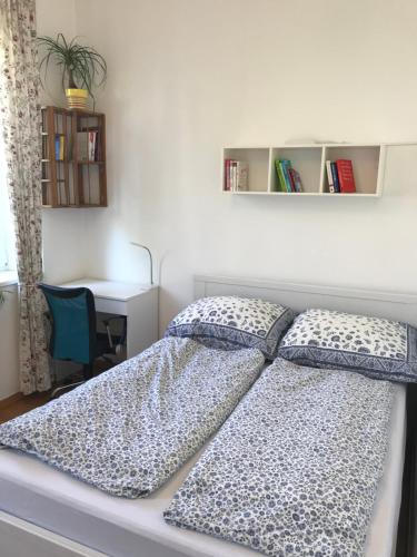 a bedroom with a bed with two pillows and a desk at Nice apartment near Schönbrunn and downtown in Vienna