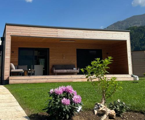 a house with a couch and flowers in the yard at Seechalet Linsendorf in Saager