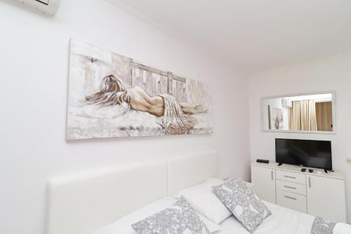 a white living room with a painting on the wall at Hotel Pansion Villa Antonio in Orebić