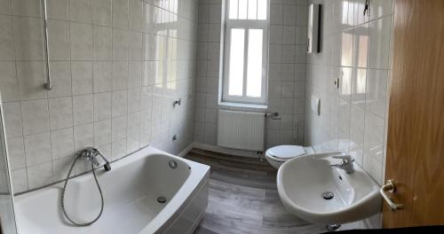 a bathroom with a tub and a sink and a toilet at MRS in Hürth