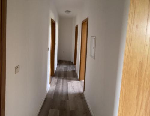 an empty hallway with white walls and wooden doors at MRS in Hürth
