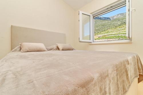 a bedroom with a large bed with a window at Hotel Pansion Villa Antonio in Orebić