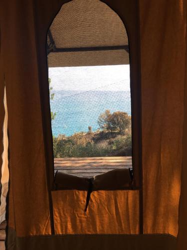 a view of the ocean from a window of a tent at Càmping Kanguro in San Pol de Mar
