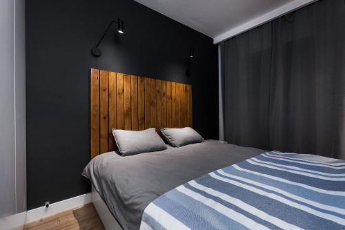 グダニスクにあるUroczy Apartament w Sercu Starego Miastaのベッドルーム1室(大型ベッド1台、木製ヘッドボード付)