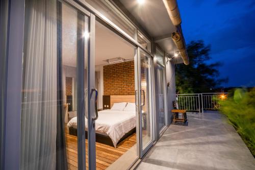 a bedroom with a bed on a balcony at Lushy Hostel Canggu in Canggu