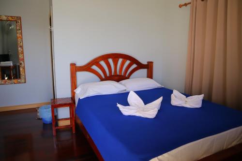 a blue bed with two white pillows on it at Ban Sulada Guest House in Laem Ngop