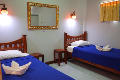 a bedroom with two beds with a mirror at Ban Sulada Guest House in Laem Ngop
